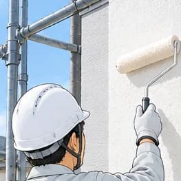 足場の上でローラーを使って外壁を塗る職人