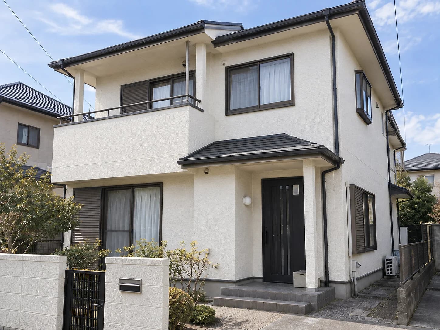 塗り替え後の戸建て住宅。明るいアイボリーの外壁